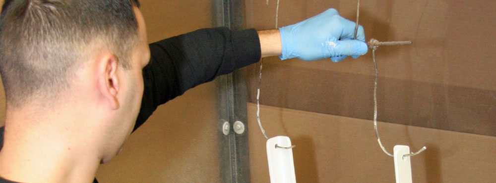 A man hanging parts to be fluid bed coated.