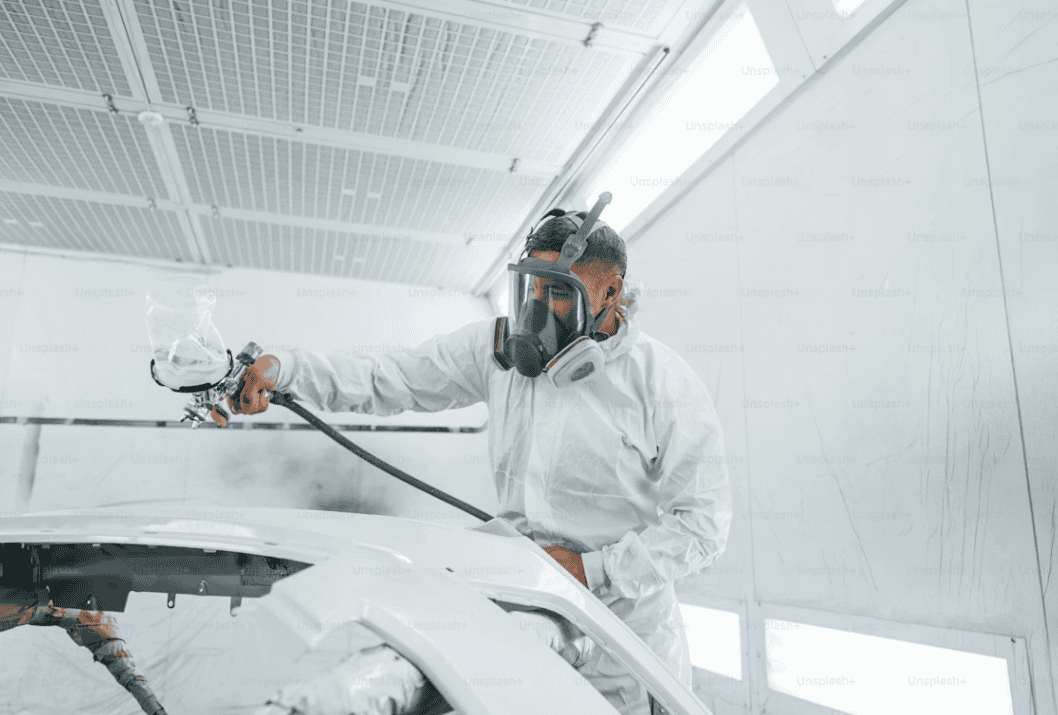 A man working in a spray-coating shop.