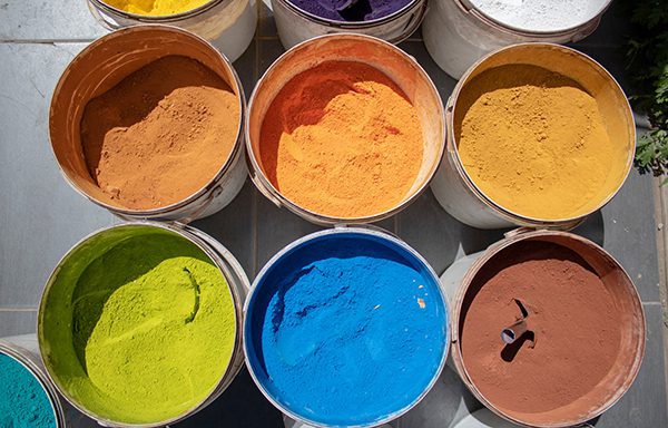 A number of tubs filled with powder coating in different colors