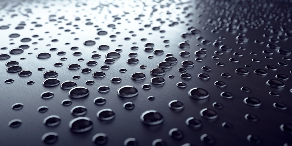 Water drops beaded on a black surface