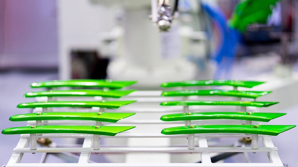 A display of long, thin metal pieces coated with bright green PTFE.
