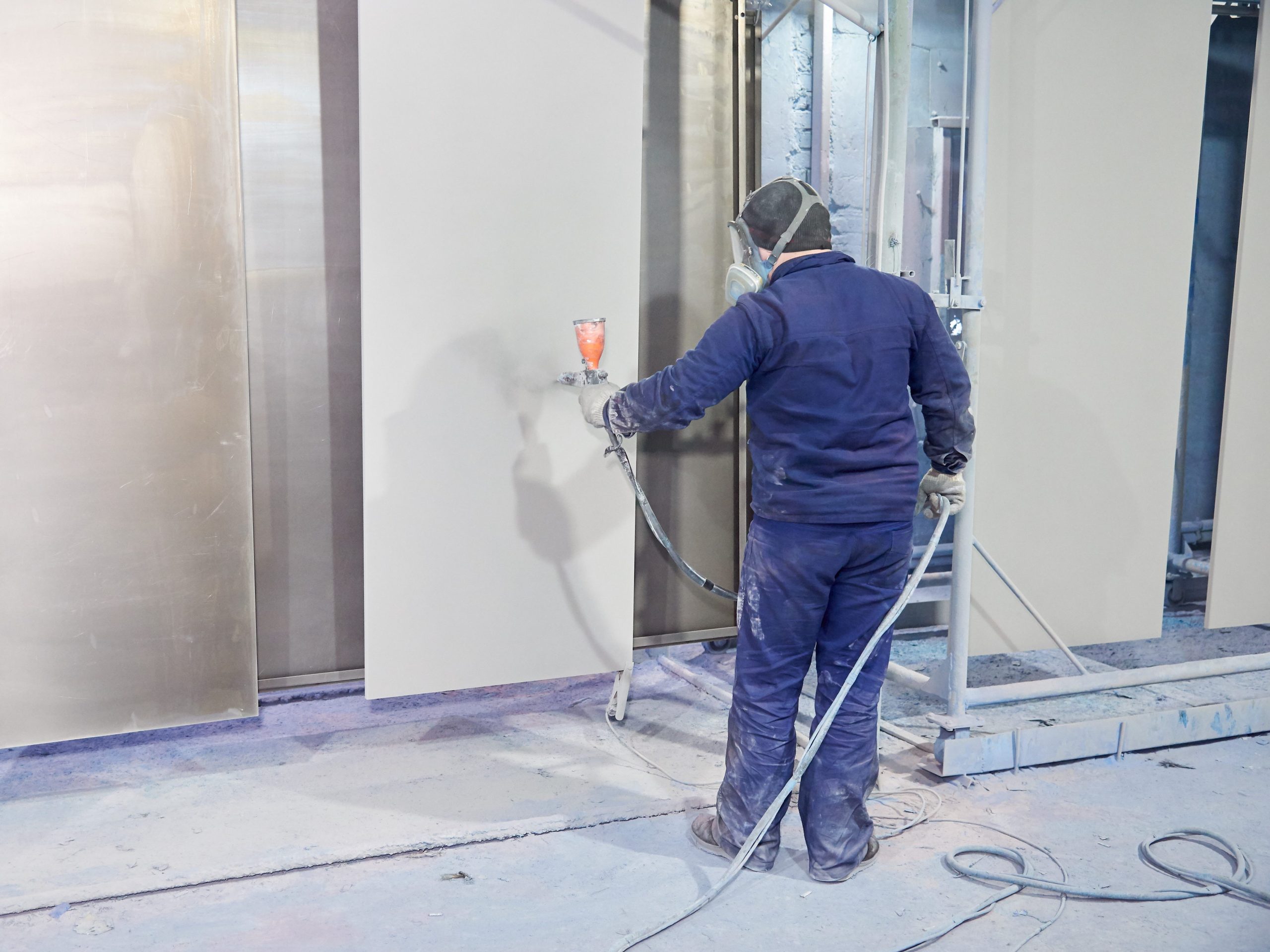 A man produces powder paint metal products.